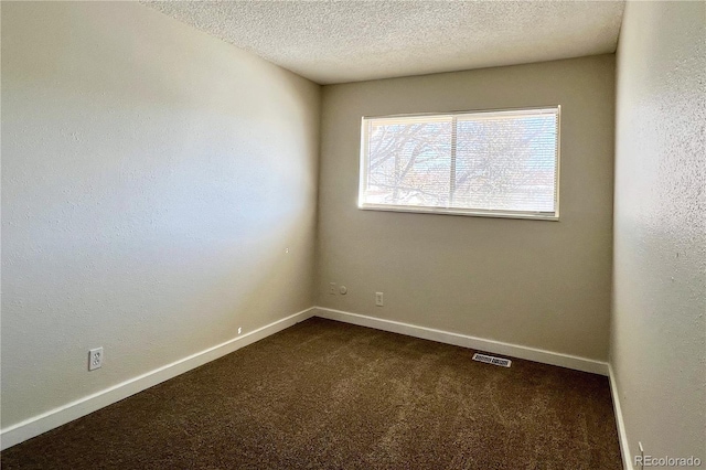 carpeted empty room featuring a textured ceiling