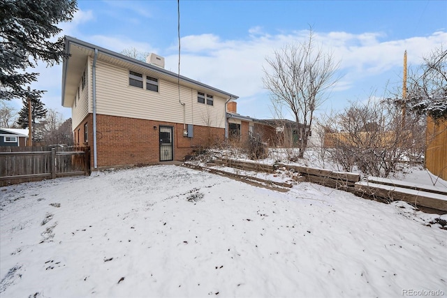 view of snow covered back of property