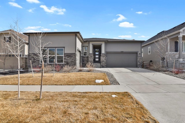 view of front facade with a front yard, stone siding, an attached garage, and concrete driveway