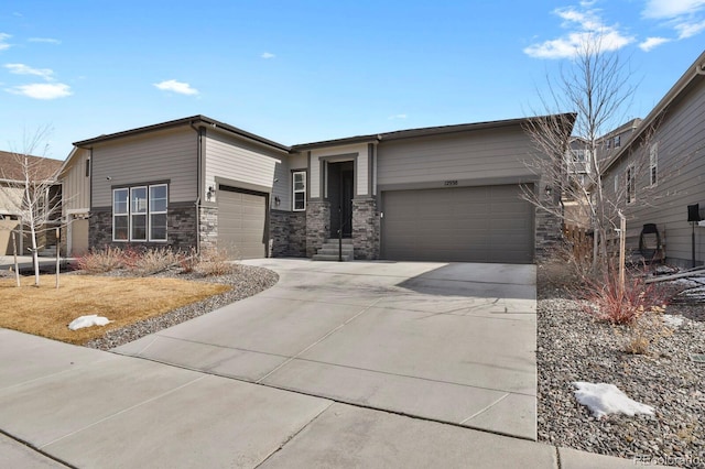 view of front of house with concrete driveway, stone siding, and an attached garage