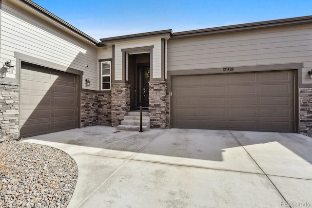 view of front facade featuring a garage, stone siding, and driveway