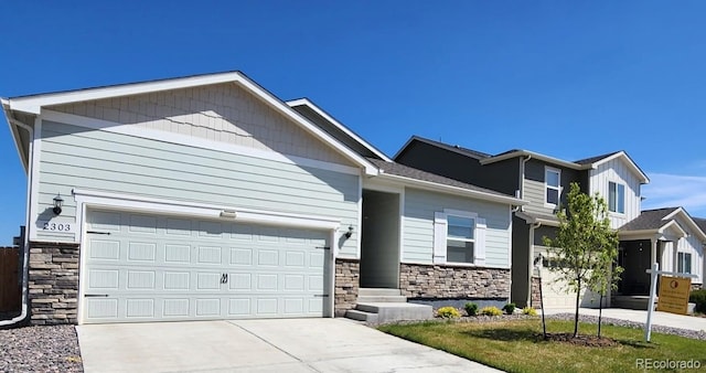 view of front of property featuring a garage, driveway, and stone siding