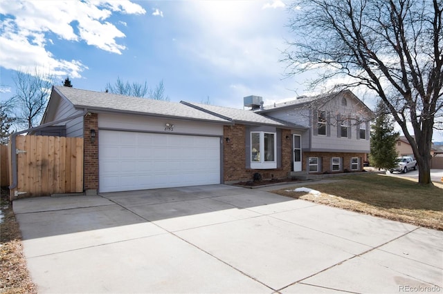 tri-level home featuring a garage and a front yard