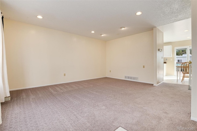 carpeted spare room featuring a textured ceiling