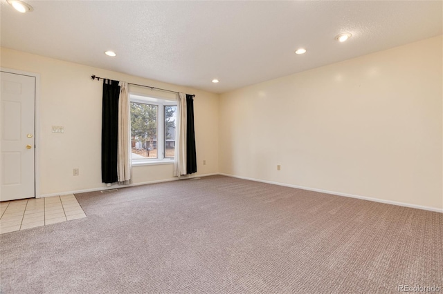 carpeted empty room with a textured ceiling