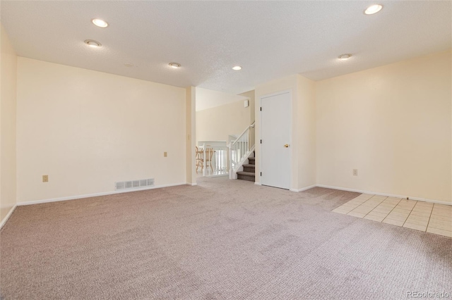 carpeted empty room with a textured ceiling