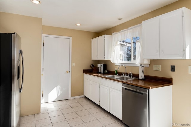 kitchen featuring white cabinetry, appliances with stainless steel finishes, sink, and light tile patterned floors