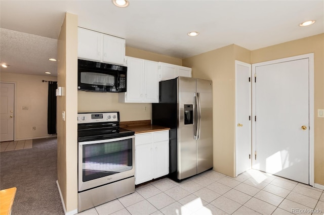 kitchen featuring appliances with stainless steel finishes, light tile patterned floors, and white cabinets