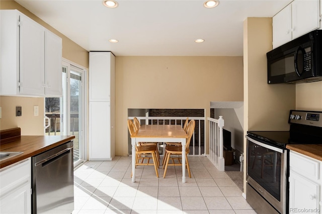 kitchen featuring white cabinetry, stainless steel electric stove, light tile patterned floors, and dishwashing machine