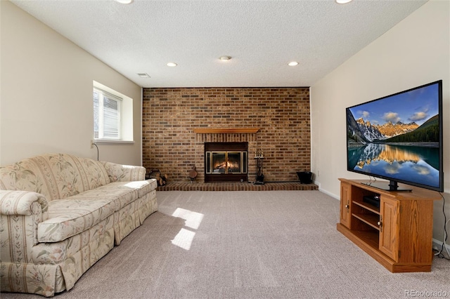 living room featuring a fireplace, light carpet, and a textured ceiling