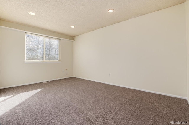 empty room featuring carpet and a textured ceiling