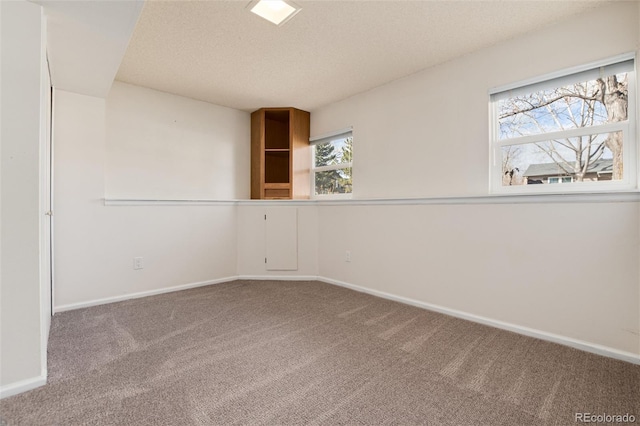 empty room with a textured ceiling and carpet