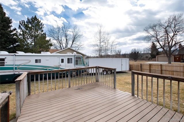 wooden deck with a yard and a storage shed