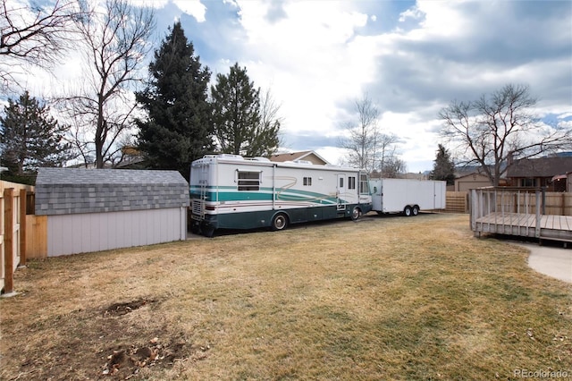 view of yard featuring a storage unit and a deck