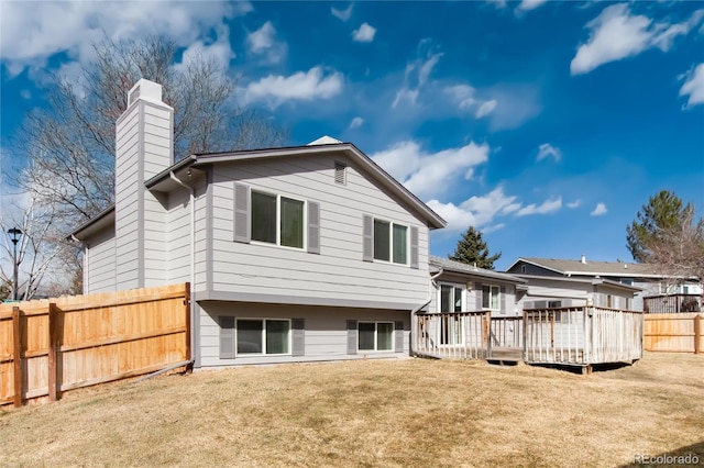 rear view of house featuring a yard and a deck