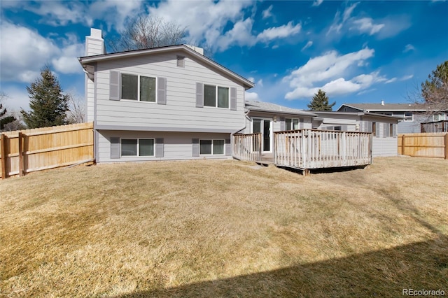 rear view of house with a wooden deck and a lawn