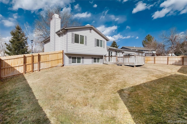 back of house featuring a wooden deck and a yard