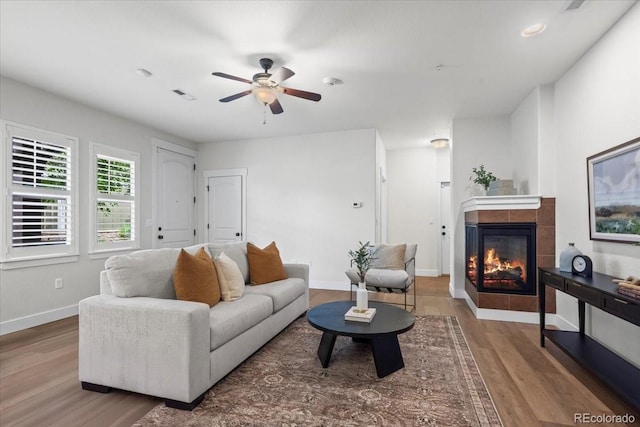 5850 Dripping Rock Ln Unit G102, Fort Collins, CO 80528 - living room with a fireplace, wood finished floors, ceiling fan, and baseboards