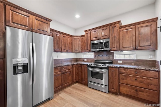 5850 Dripping Rock Ln Unit G102, Fort Collins, CO 80528 - kitchen with appliances with stainless steel finishes, light wood-style floors, dark stone countertops, backsplash, and recessed lighting