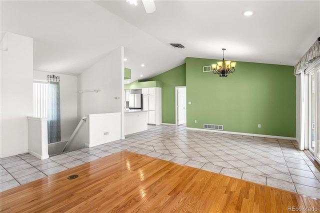 465 W Palmer Lake Dr, Pueblo, CO 81007 - unfurnished living room with light tile patterned floors, lofted ceiling, a chandelier, healthy amount of natural light, and recessed lighting