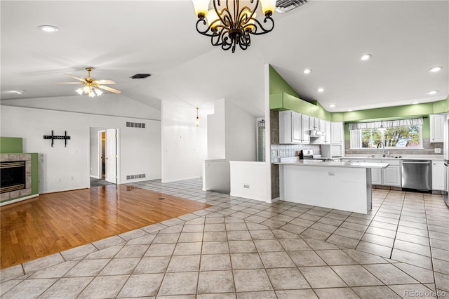 465 W Palmer Lake Dr, Pueblo, CO 81007 - kitchen featuring stainless steel dishwasher, open floor plan, vaulted ceiling, a chandelier, and decorative backsplash