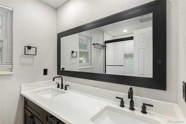 10051 E Walsh Pl, Denver, CO 80247 - full bath with a textured wall, double vanity, and tiled shower