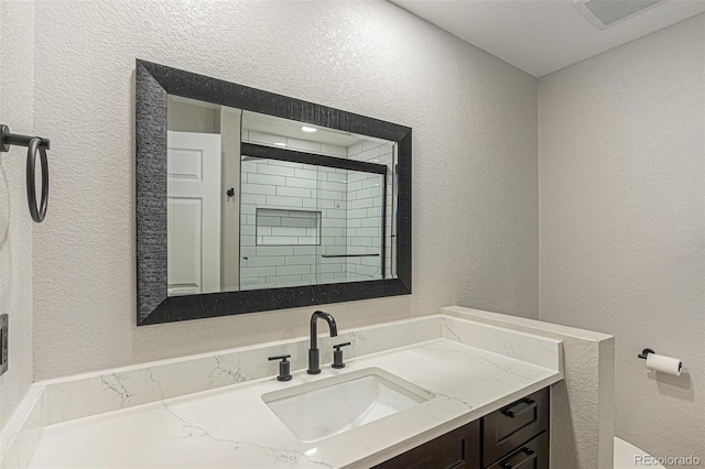 10051 E Walsh Pl, Denver, CO 80247 - bathroom featuring a textured wall, vanity, and a shower
