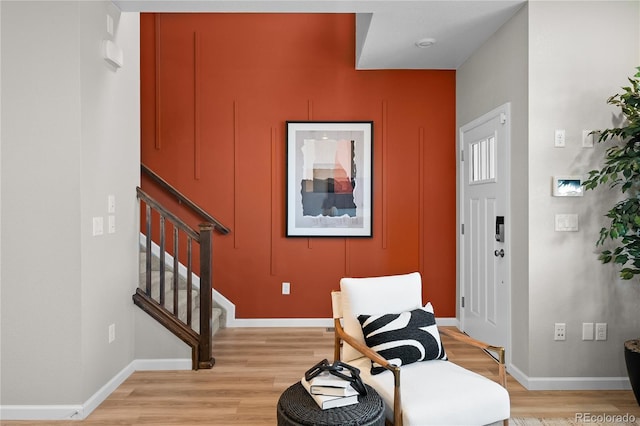 sitting room with light wood-style floors, stairs, and baseboards