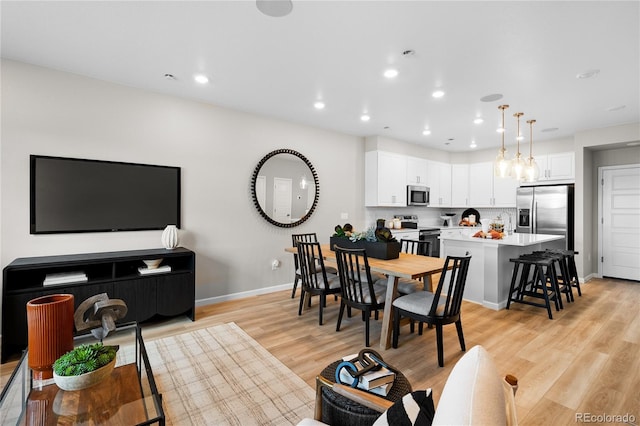 dining area featuring light wood-style floors, baseboards, and recessed lighting