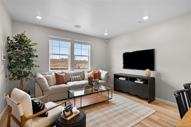 living room featuring baseboards, recessed lighting, and light wood-style flooring
