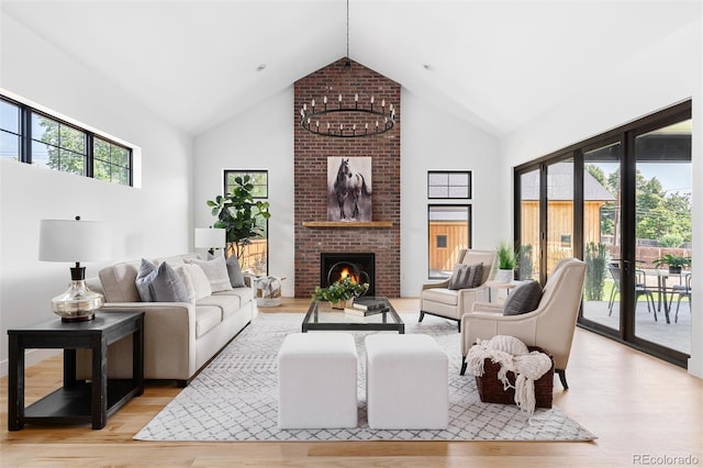 living room with high vaulted ceiling, plenty of natural light, and light hardwood / wood-style flooring