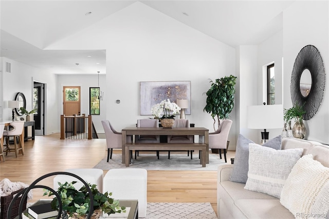 living room with light hardwood / wood-style floors and vaulted ceiling