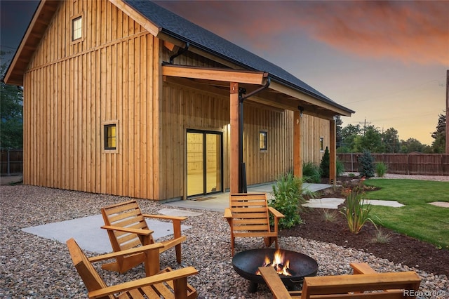 back house at dusk with an outdoor fire pit