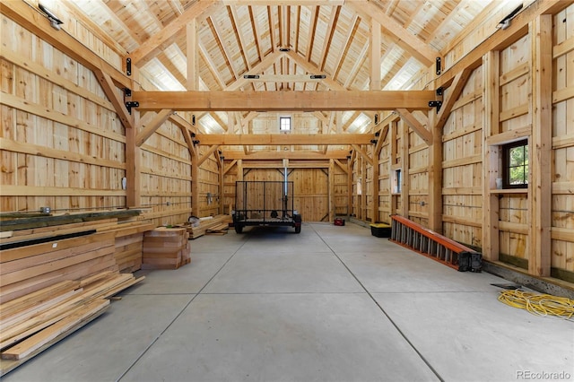 interior space with beamed ceiling, concrete flooring, and high vaulted ceiling