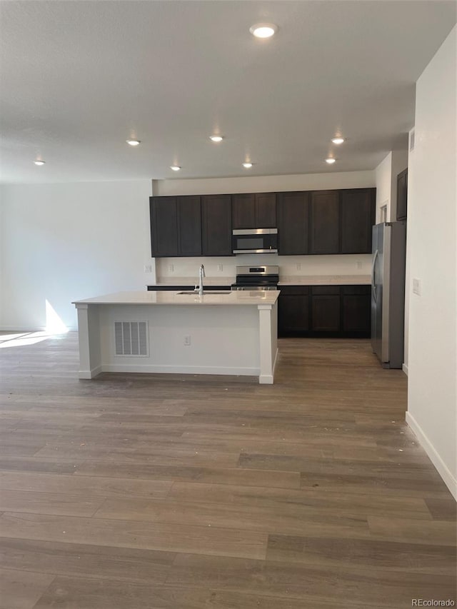 6750 Juniper Dr, Thornton, CO 80602 - kitchen with stainless steel appliances, recessed lighting, wood finished floors, a sink, and baseboards