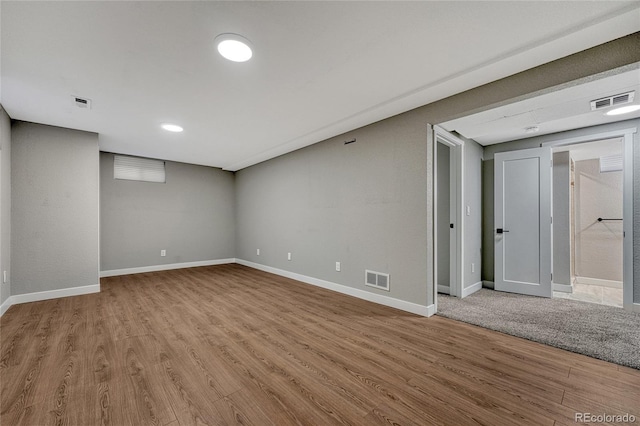 interior space with wood finished floors, visible vents, and baseboards