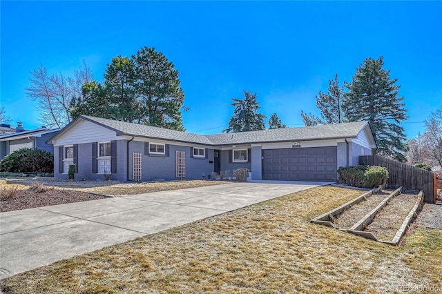 ranch-style home with brick siding, fence, concrete driveway, a garage, and a garden