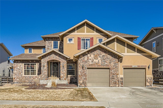 craftsman-style home featuring a garage, concrete driveway, roof with shingles, and stucco siding