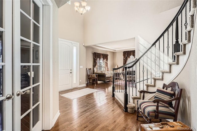 entryway with stairs, hardwood / wood-style floors, baseboards, and an inviting chandelier