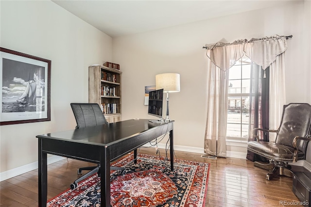 home office with wood-type flooring and baseboards