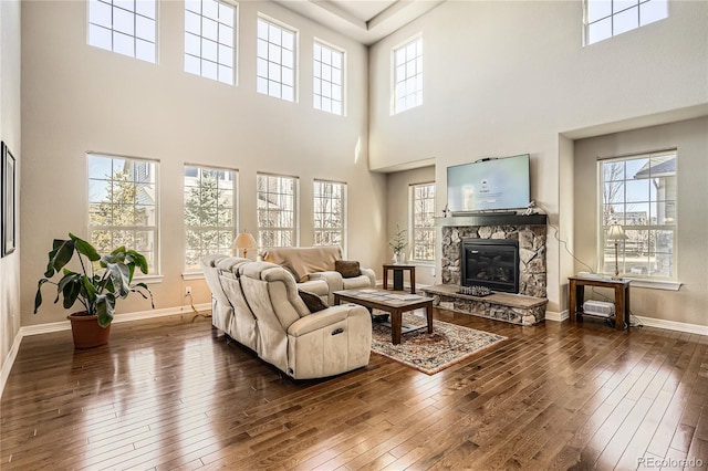 living room featuring dark wood-style floors, a fireplace, and baseboards