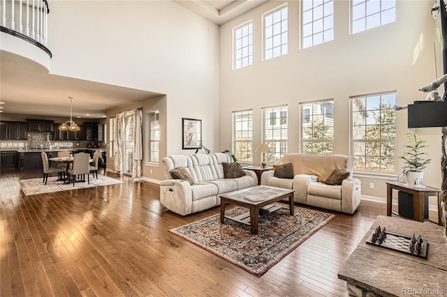 living area with a healthy amount of sunlight, baseboards, and dark wood-type flooring