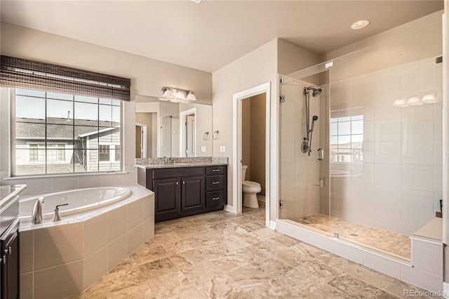 bathroom featuring a garden tub, vanity, a shower stall, and toilet