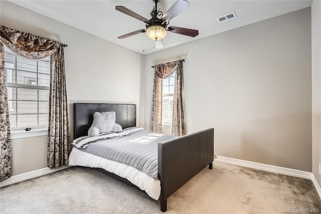 carpeted bedroom featuring visible vents, ceiling fan, and baseboards