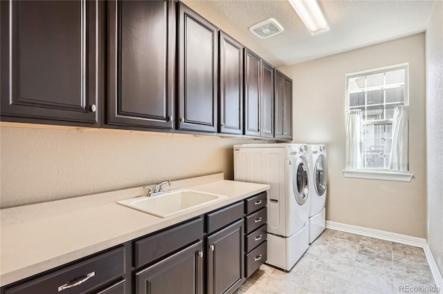 laundry room featuring cabinet space, visible vents, a sink, independent washer and dryer, and baseboards