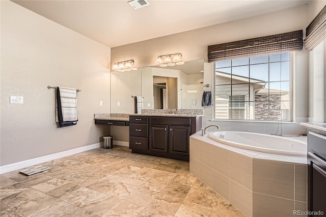 full bathroom featuring a bath, vanity, visible vents, and baseboards