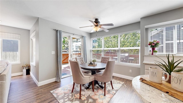 dining space featuring a ceiling fan, wood finished floors, and baseboards