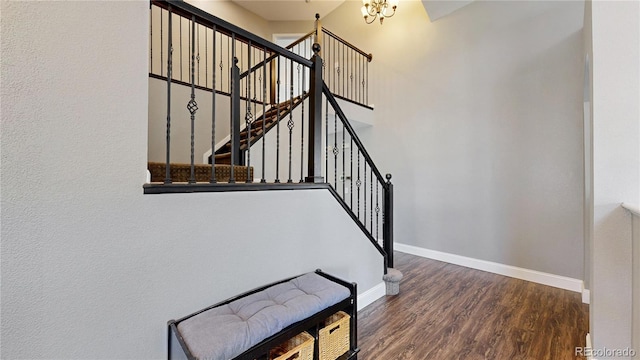 stairway featuring baseboards, wood finished floors, and a chandelier
