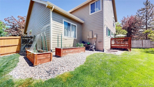 rear view of property with a garden and a deck