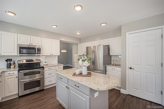 2980 E 135th Dr, Thornton, CO 80241 - kitchen featuring appliances with stainless steel finishes, white cabinetry, tasteful backsplash, a kitchen island, and dark wood-style flooring